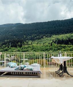 a bed on a balcony with a view of a mountain at Freeze Inn Mestia in Mestia
