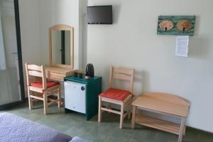a room with two chairs and a table and a mirror at Eri Rooms to Let in Raches