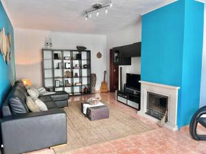 a living room with a couch and a fireplace at Andorinha Levante in Grândola