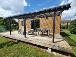 un pabellón con mesa y sillas en una terraza de madera en Gîte et chambre d'hôtes en Champagne, en Courtisols