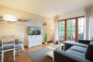 a living room with a couch and a table with a tv at Landhaus Pönitz am See Wohnung 7 in Pönitz am See
