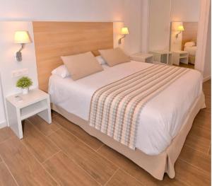 a bedroom with a large white bed and a table at Apartamentos Turísticos Gran Sol in Zahara de los Atunes +22 photos