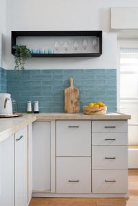 a kitchen with white cabinets and blue tiles at Cozy Rehavia for families in Jerusalem