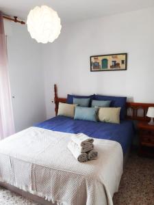 Un dormitorio con una cama azul y blanca con toallas. en Los Locos Coloso 5, en Torrevieja