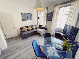 - un salon avec un canapé et une table en verre dans l'établissement Newcastle City Centre, Two Bedroom, Sleeps 6, à Newcastle upon Tyne