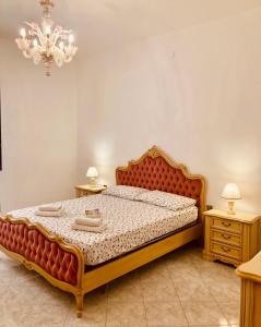 una camera da letto con un grande letto con due tavoli e un lampadario a braccio di Ai do fradei a Mestre