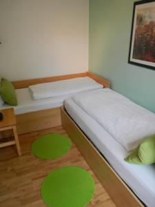 ヴェルニゲローデにあるApartment Haus Brüchertのベッドルーム1室(ベッド2台、床に緑色のマット付)