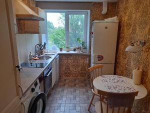 a kitchen with a table and a refrigerator and a sink at Quiet Summer Apartment in Aucugals