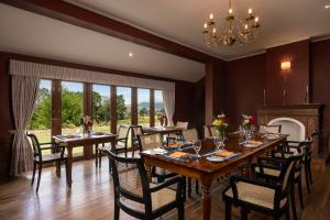 a dining room with tables and chairs and a chandelier at Broomfield by Jetwing in Nuwara Eliya
