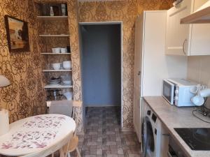 a small kitchen with a table and a microwave at Quiet Summer Apartment in Aucugals +20 photos