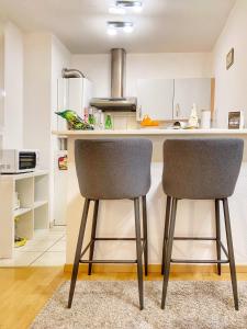 a kitchen with two chairs at a kitchen counter at Centre ville au calme , Parking privé intérieur CAR et BIKE in Saverne