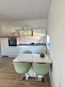 a kitchen with a white table and chairs in a room at Ferienwohnung Dariana Schwalbach/Saar in Schwalbach