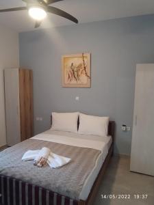 - une chambre avec un grand lit et un ventilateur de plafond dans l'établissement Pefkonas apartments2 100 m from the beach, à Psakoudia