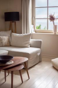 a living room with a white couch and a window at Nidos Banga in Nida