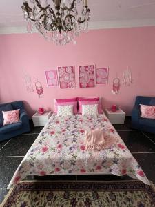 a pink bedroom with a bed and a chandelier at Casa Adele in Serravalle Scrivia