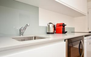 a kitchen with a sink and a red appliance at Kings Cross Serviced Apartments by Concept Apartments in London