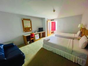 Sweet Home Hotel Betong في بيتونغ: غرفة فندقية بسريرين ومرآة