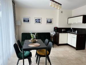a living room with a table and chairs and a kitchen at Apartament LAPIS Panorama Avangard in Świnoujście