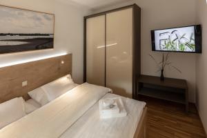 mały pokój z łóżkiem i telewizorem w obiekcie Pannonia Appartements 2 w mieście Neusiedl am See