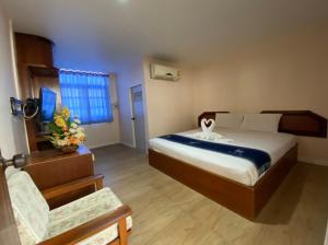 ein Schlafzimmer mit einem Bett und einem Stuhl darin in der Unterkunft Imperial Sakon Hotel in Sakon Nakhon