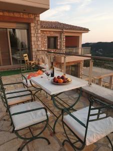 uma mesa e cadeiras com um prato de frutas num pátio em Lavender House 2 - Agios Nikitas em Ayios Nikitas