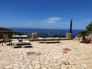 um pátio com uma mesa e cadeiras e o oceano em Lavender House 2 - Agios Nikitas em Ayios Nikitas