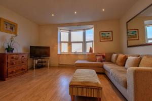 a living room with a couch and a television at Victoria Parade: Perfect family apartment over looking Viking Bay, stones throw from the beach and town in Broadstairs