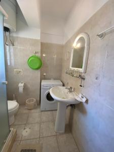 a bathroom with a sink and a washing machine at Mariangela Apartments in Lixouri