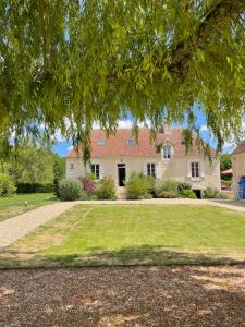 a large house with a large lawn in front of it at Domaine de La Vove - Maison d'hôtes classée, cadre paisible et naturel - ambiance insolite jardin paysager doté d'une terrasse spacieuse - une vue panoramique exceptionnelle -authenticité et élégance in Corbon