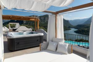 a bedroom with a tub on a balcony with a view at Hotel Villa Cedrino in Dorgali