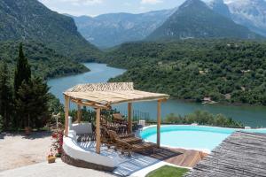 a resort with a swimming pool and a view of a mountain at Hotel Villa Cedrino in Dorgali