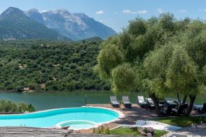 a swimming pool with a view of a river and mountains at Hotel Villa Cedrino in Dorgali