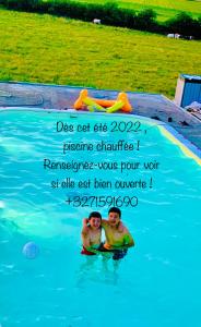 twee mensen in het water in een zwembad bij Domaine de falimont à Labuissière in Merbes-le-Château