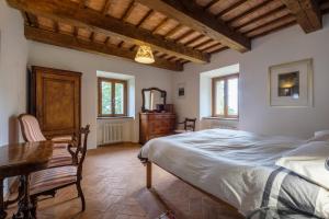Schlafzimmer mit einem Bett, einem Tisch und einem Schreibtisch in der Unterkunft Casale Roccone in Piancastagnaio
