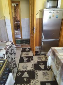 a kitchen with a refrigerator and some rugs on the floor at Радуга in Podobovets