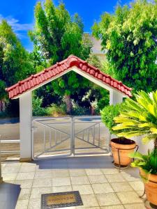 a gazebo with a red roof and some plants at Kallipateira apartments in Rhodes Town