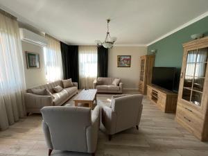 a living room with couches and a flat screen tv at Fortuna Panorama Apartman in Odorheiu Secuiesc