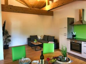 a living room with green chairs and a couch at Ferienwohnung Kaindl in Chieming