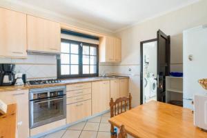 a kitchen with wooden cabinets and a wooden table with a wooden table sidx sidx sidx at PERLE DES MEERES in Charco del Palo