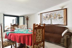 a dining room with a table and a couch at Appartamento Holiday in Cala Gonone +21 photos