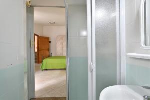 a bathroom with a glass door leading to a bedroom at Appartamento Holiday in Cala Gonone
