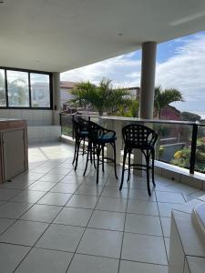 a porch with chairs and tables on a balcony at Trevi Sea-view Apartment in Margate