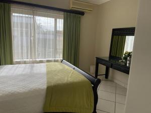 1 dormitorio con cama, escritorio y ventana en Trevi Sea-view Apartment, en Margate