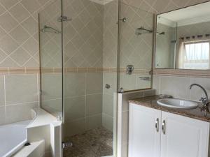 a bathroom with a shower and a sink and a mirror at Trevi Sea-view Apartment in Margate
