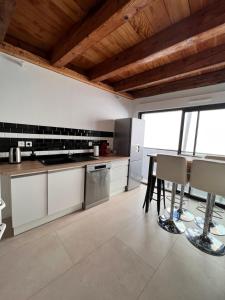 a kitchen with white cabinets and a table and chairs at Beau T3 au cœur du centre ville in Narbonne