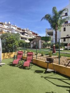 un grupo de sillas y una mesa en un césped en Costa Esuri, en Ayamonte