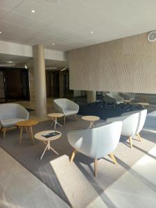 a lobby with chairs and tables in a building at Hotelli Fennada in Vierumäki