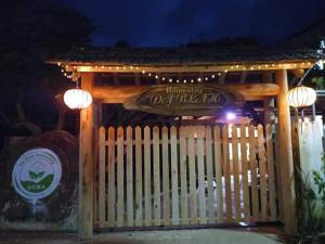 un portail en bois avec un panneau et une clôture dans l'établissement Homestay Da Blah, à Da Ðeum (2)