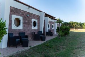 a group of chairs sitting outside of a building at La Meta Sporting Rooms in Alghero