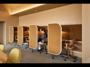 a man sitting at a table in a waiting room at 9h nine hours woman Shinjuku in Tokyo